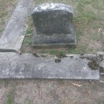 Headstone of John and Jane Hart, displaying their names and dates, set in a serene cemetery landscape